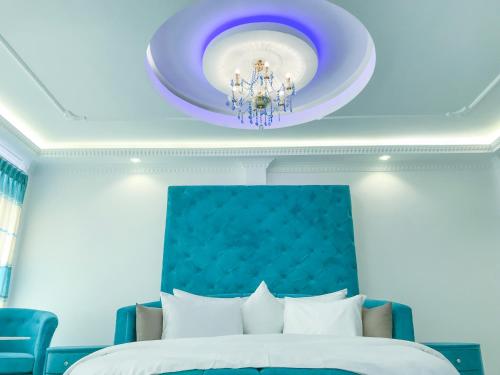 a bedroom with a blue ceiling with a chandelier at The Lion Kingdom Sigiriya in Sigiriya
