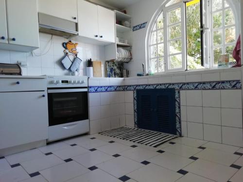 cocina blanca con fogones y ventana en Casa Zona Playa, en Vigo