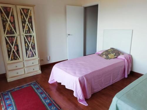 1 dormitorio con 1 cama rosa y armario en Casa Zona Playa, en Vigo