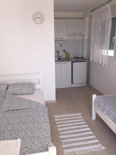 a white room with two beds and a kitchen at Apartments Mia Patria in Ulcinj