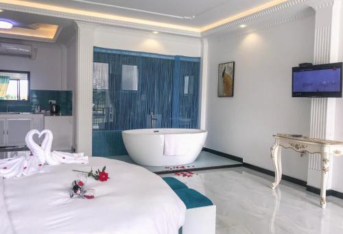 a white bathroom with a tub and a bed with flowers at The Lion Kingdom Sigiriya in Sigiriya