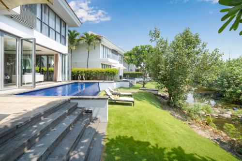 峴港的住宿－Blue Sky & Villas Beach Resort，一个带游泳池和房子的后院