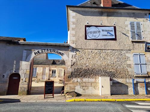 an old stone building with a sign on it at Au P'tit Gueul'ton in Les Aix-dʼAngillon