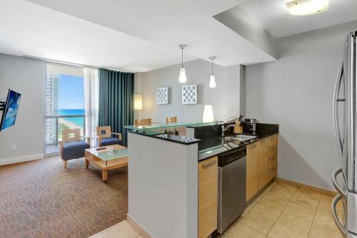 a kitchen with a counter and a living room at Beachfront with direct beach access and amazing views in Aventura