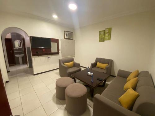 een woonkamer met een bank en een tafel bij نون للشقق المفروشة in Jazan