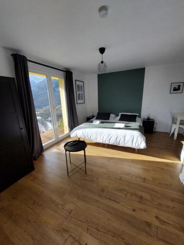 a bedroom with a bed and a large window at Résidence E CIME ASCO in Asco