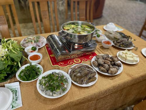 a table with plates of food on a table at Phuong Dong Hotel in Cat Ba