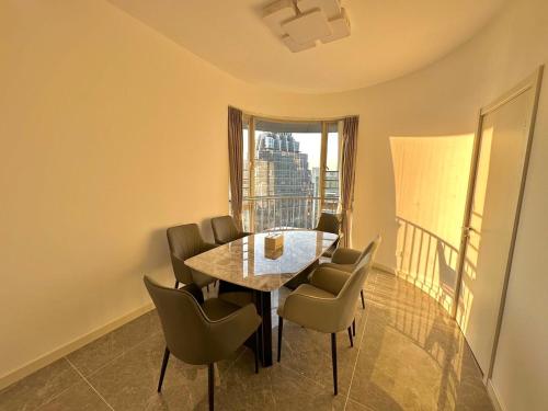 a dining room with a table and chairs and a window at Shanghai Shining River Apartment -Near the Bund in Shanghai