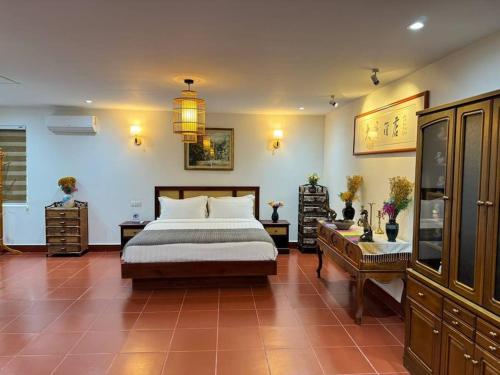 a bedroom with a large bed and two tables and a table at Manil Home Stay - 3 Beds Room in Siem Reap