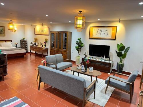 uma sala de estar com sofás e uma televisão em Manil Home Stay - 3 Beds Room em Siem Reap