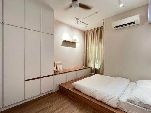 a bedroom with white walls and a bed with a wooden floor at Nordic Minimalist Kajang Getaway in Kajang