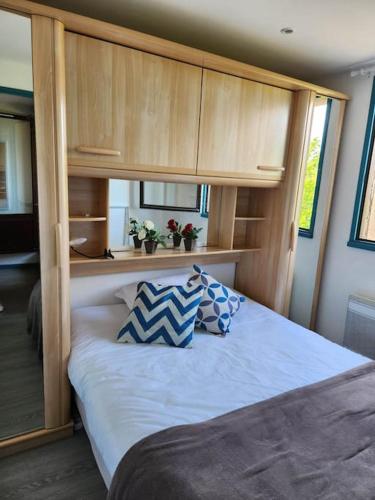 - une chambre avec un grand lit et des placards en bois dans l'établissement Biscarrosse - Plage à 300m Superbe appart. 4 Pers, à Biscarrosse