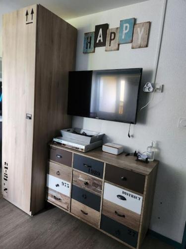 - un centre de divertissement avec une télévision murale à écran plat dans l'établissement Biscarrosse - Plage à 300m Superbe appart. 4 Pers, à Biscarrosse