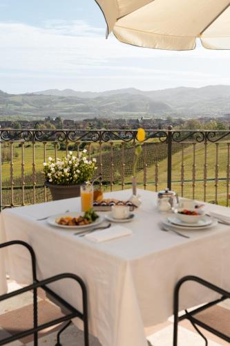 a white table with plates of food on a balcony at Hotel Villa La Bollina in Serravalle Scrivia