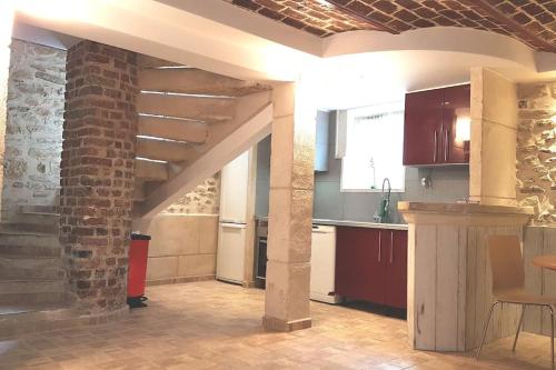 - une cuisine décloisonnée avec un mur en briques dans l'établissement à 15mn de Paris et Stade de France, appartement 4 pièces, 6 lits, à Montmagny