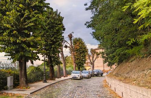 a row of cars parked on a street with trees at Relais B&B Corte Dei Turchi in Longiano