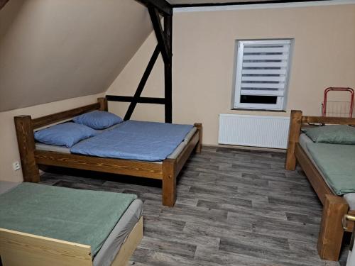 a room with two beds and a window at Chata Na Rozcestí in Loučná pod Klínovcem