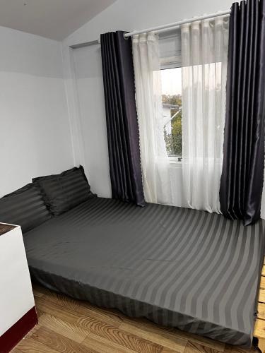 a bed in a room with a window at Garden Homestay in Di Linh