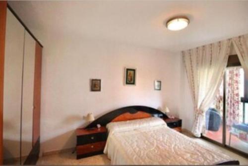 een slaapkamer met een bed en een raam bij Casa Adriana, balcon y parking Habitacion en piso compartido in Almuñécar