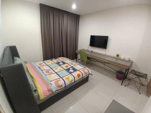 Schlafzimmer mit einem Bett und einem Schreibtisch mit einem Computer in der Unterkunft Kozi Square with Infinity Pool II in Kuching