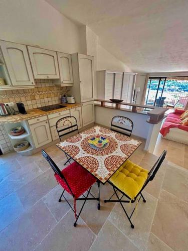une cuisine avec une table et des chaises ainsi qu'un astérisque dans l'établissement Petit Mas Coquet dans l'Esterel, à Théoule-sur-Mer