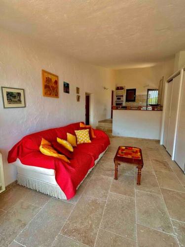 - une chambre avec un grand canapé rouge et des oreillers jaunes dans l'établissement Petit Mas Coquet dans l'Esterel, à Théoule-sur-Mer