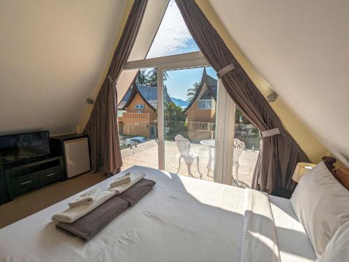 ein Schlafzimmer mit einem Bett und einem großen Fenster in der Unterkunft Koh Chang Pool Villa - by KohChangVillas in Ko Chang