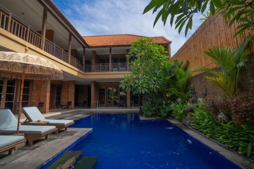 a villa with a swimming pool and a house at Wiras Village in Canggu