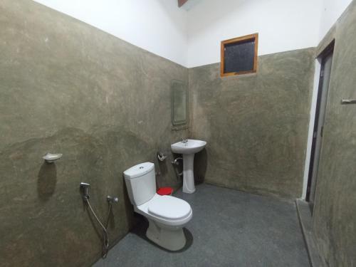 La salle de bains est pourvue de toilettes et d'un lavabo. dans l'établissement WILAPTTU WILD VILLA, à Pahala Maragahawewa