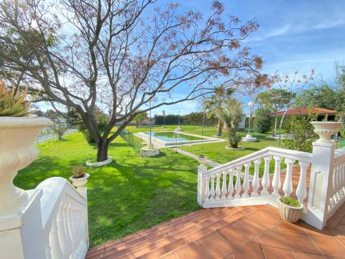 a porch with a white railing and a yard at VILLA LÚA in Cartaya
