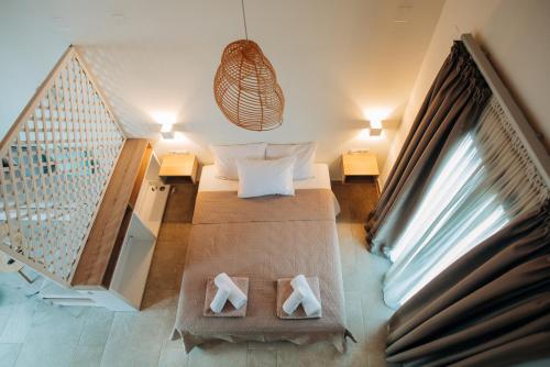 a room with a bed and two tables and a staircase at Villa di Vino in Lefkada