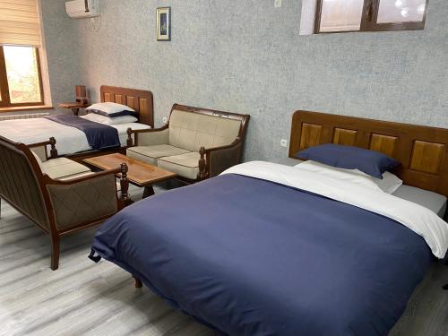 a hotel room with two beds and a chair at Cinzano Complex in Samarkand