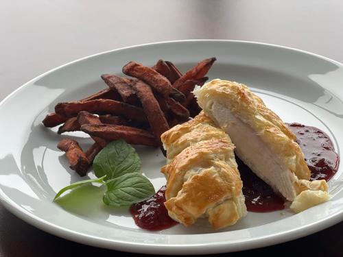 a plate of food with a pastry and french fries at Hotel Eurobus in Kaluža