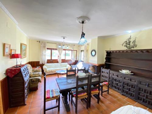 a living room with a table and a large piano at VILLA LÚA in Cartaya