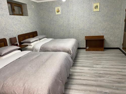 a hotel room with two beds and a table at Cinzano Complex in Samarkand