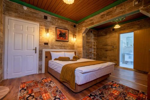 a bedroom with a bed in a room with wooden walls at ARTON İN CAPPADOCİA HOTEL in Avanos