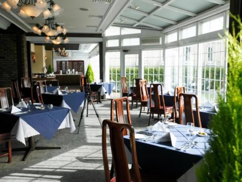 un restaurante con mesas y sillas azules y ventanas en Wellness Forest Nasu en Nasu