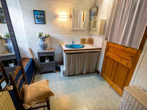 a small bathroom with a sink and a wooden door at Bergerie Ariégeoise in Ustou