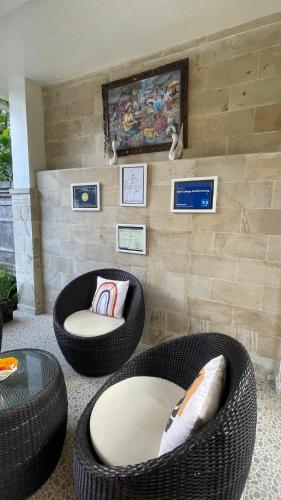 a living room with two chairs and two ottomans at Bali Cottage Sambirenteng in Buleleng