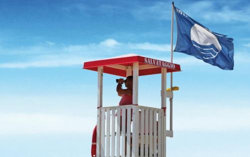 a person in a lifeguard tower with a flag at Village Camping Joker in Cavallino-Treporti