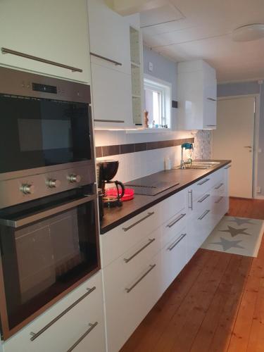 エルムフルトにあるGullrandaの白いキャビネットと大型オーブン付きのキッチンが備わります。