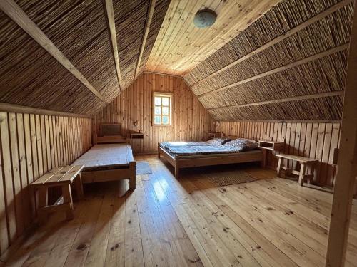 um quarto amplo com 2 camas e um tecto de madeira em Labanoro pasaka - Elenutės namai em Berniūnai