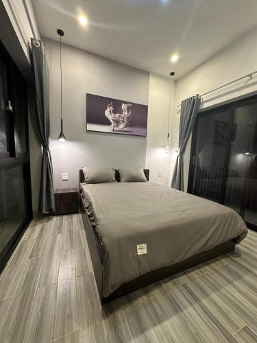 a bedroom with a bed and a painting on the wall at Relax Homestay - Đảo Phú Quý in Cu Lao Thu