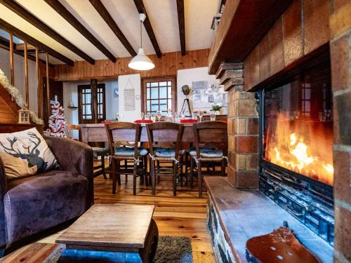 a living room with a fireplace and a table and chairs at Bergerie Ariégeoise in Ustou