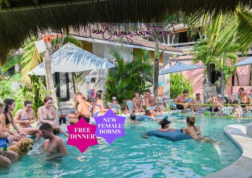 un grupo de personas sentadas en la piscina de un complejo en Clandestino Hostel Canggu, en Canggu