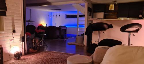 una sala de estar con sofá y una habitación con luces azules en Casa Mirissa en Moordrecht