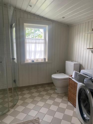 uma casa de banho com um WC, uma janela e uma máquina de lavar roupa em Änden på Säby Tjörn em Säby