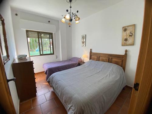 a bedroom with two beds and a chandelier at VILLA LÚA in Cartaya