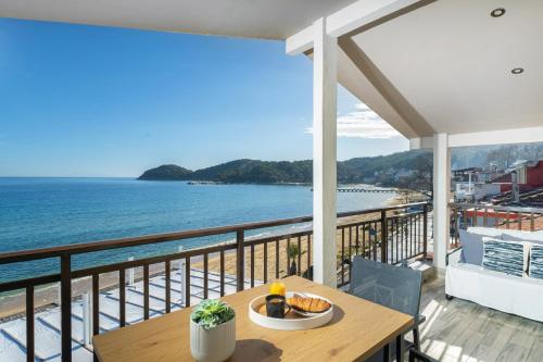 a table on a balcony with a view of the ocean at Dimar Apartments in Olympiada