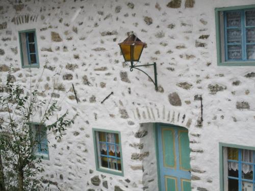a stone building with a blue door and a street light at Pri Macku in Tolmin